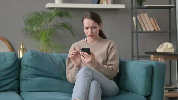 Woman Having Loss on Smartphone at Home