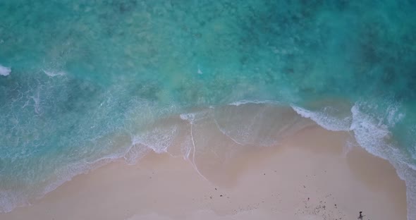 Natural fly over travel shot of a paradise sunny white sand beach and turquoise sea background 