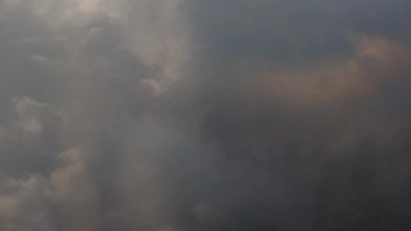 Sea being revealed from clouds from air plane window.