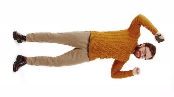 Happy European Bearded Guy in Knitted Swearer and Elegant Shoes with Red Socks Dancing in a Studio