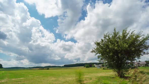 Time lapse of clouds and high clouds moving in different direction over field at countryside