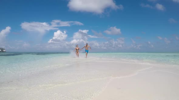 Happy couple running and having fun at seaside