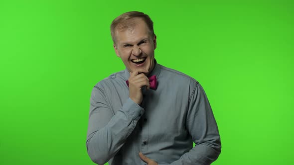 Man Holding Belly and Laughing Out Loud with Tears, Feeling Carefree Joyful After Hearing Funny Joke