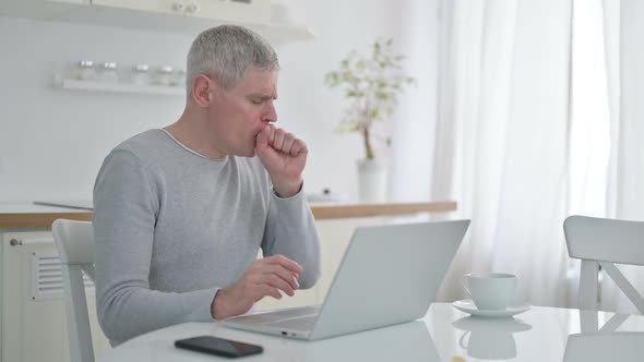 Sick Senior Old Man with Laptop Coughing at Home