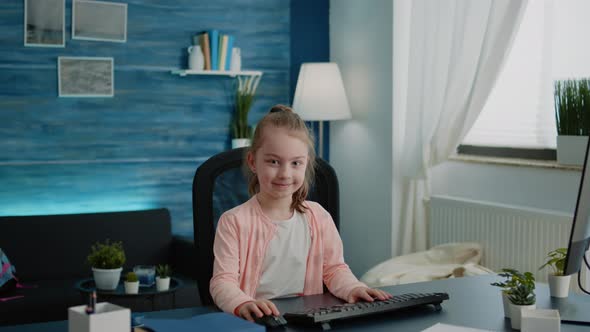 Portrait of Child Sitting at Desk with Computer for Online Lessons