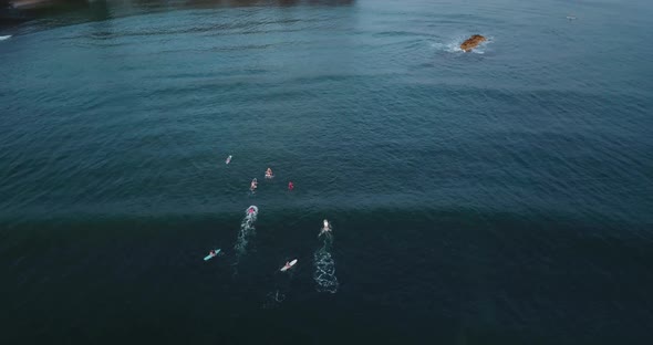 Drone shot of a beach on the North Shore of hawaii. Surfers chilling on the water waiting for waves.