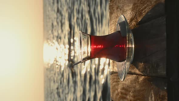 A cup of hot tea on the table. Sunset on the background of the sea shore