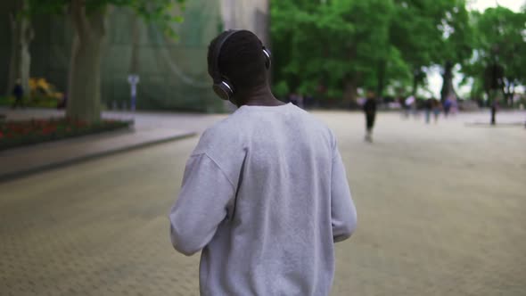 Slow Motion of Joyful African American Guy in Casual Clothing Dancing Freerly Moving in Headphones