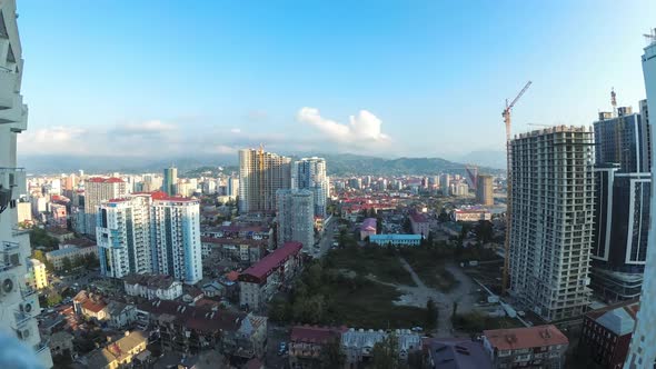 City Space with Construction Site, Skyscrapers, Traffic, and Mountains. Timelapse. Batumi, Georgia