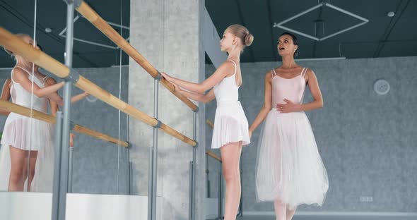 Teacher Explains Exercise To Girl Ballerina in Dance Studio