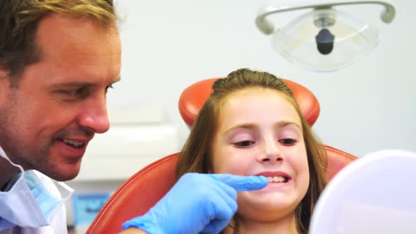 Dentist showing girls teeth on mirror