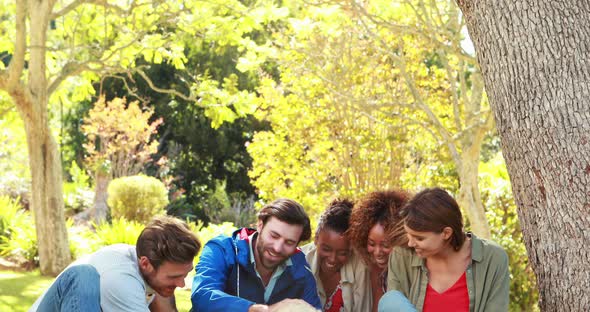 Group of happy friends sitting together with the dog