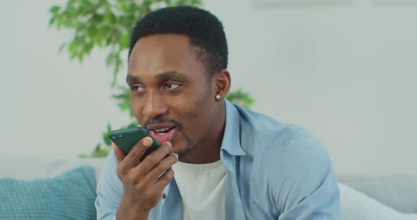 Young Man Recording Voice Recognition Message on Speakerphone