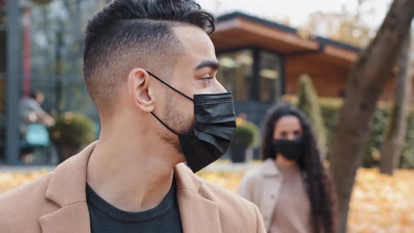 Closeup Portrait Spanish Man in Medical Mask Outdoors Foreground Guy Turning Back Looks at