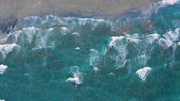 Bird's eye view of Sea Waves Crashing. Flying above sand beach. Fly over ocean coast line 