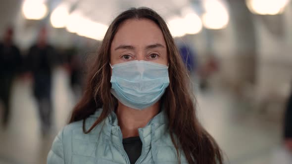 Portrait of a Brunette with Long Hair and Wearing a Medical Disposable Mask