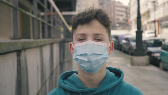 A teenager in a disposable medical protective mask on the street