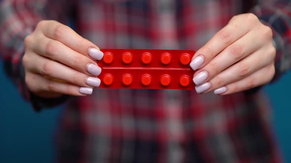 Woman Presenting a Hand of Foil-wrapped Pills