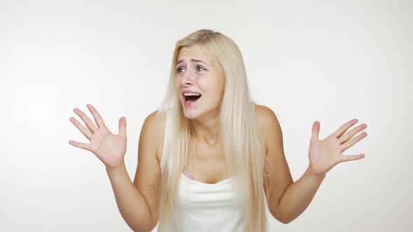 Young Blond Woman Getting Hysterical Shouting Covering Ears with Hands Doesn't Want to Listen
