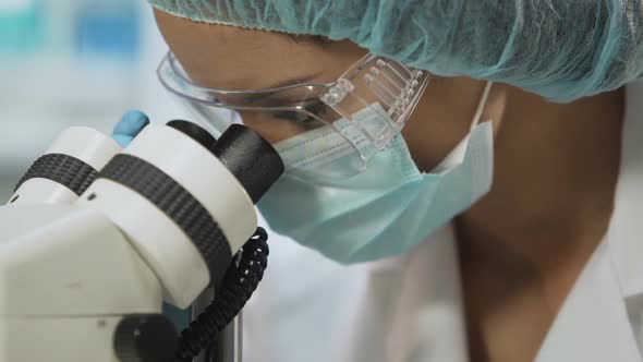 Medical Researcher Looking Through Microscope, Biochemical Research, Medicine