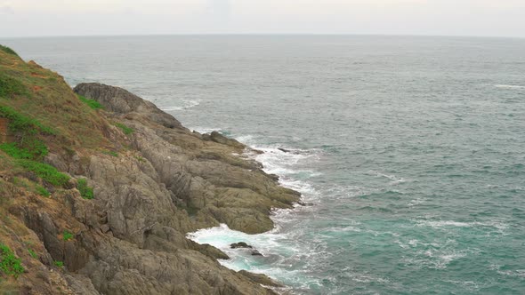 Tropical Seascape at Summer Cloudy Day. Sea Waves Break on Stony Shore