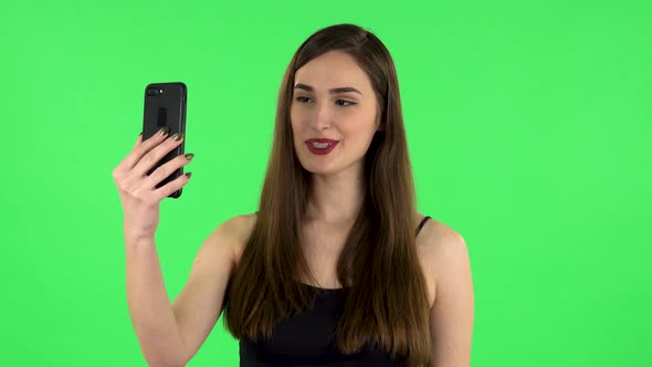 Smiling Girl Talking for Video Chat Using Mobile Phone on Green Screen