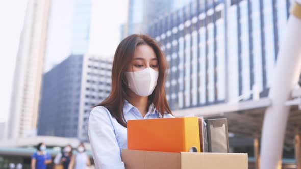 Woman with Mask Fired From Job Holding Box of Items