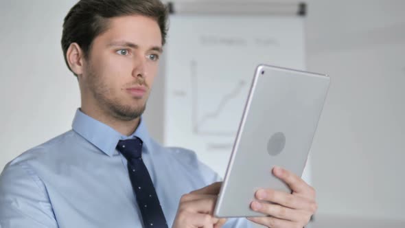 Close Up of Young Businessman Using Tablet in Office