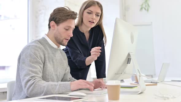 Creative People Discussing and Working on Desktop in Office