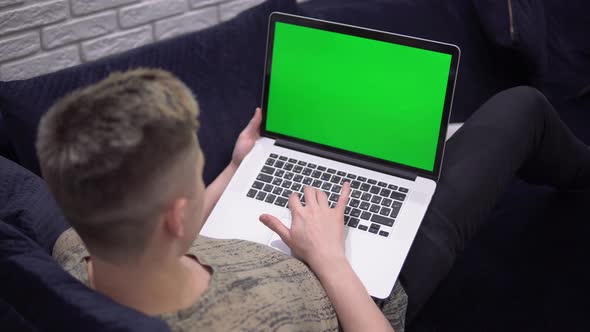 Laptop Green Screen Mockup Man Using Laptop on Sofa at Home