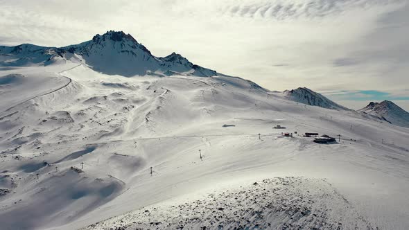 Aerial View Snow Mountain Peak Clouds in Background  Winter Drone Footage Ski Resort