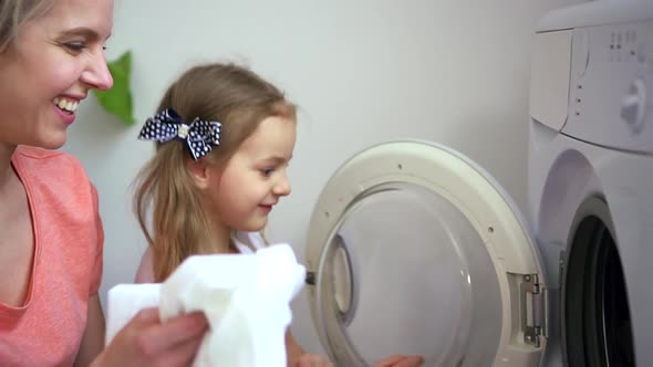 Woman and Kid Girl Load Washing Machine with Dirty Laundry Spbd