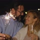 cute couple of two adults in love giving a loss together the new year night playing with sparklers - VideoHive Item for Sale