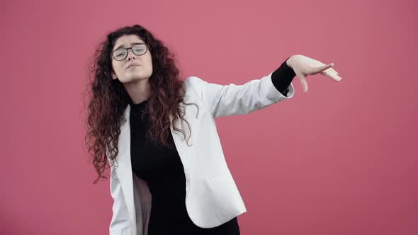 Angry Young Woman with Curly Hair She Looks with Her Hand to Push Away Because She Can't See