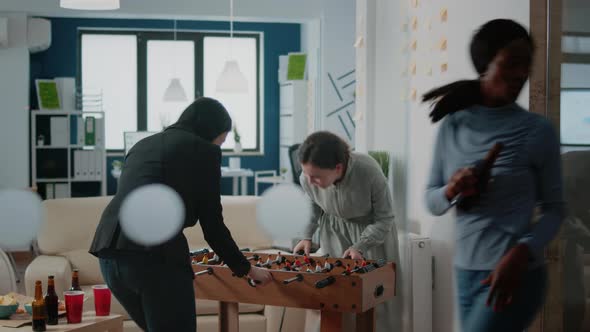 Cheerful Women Playing at Foosball Game Table After Work