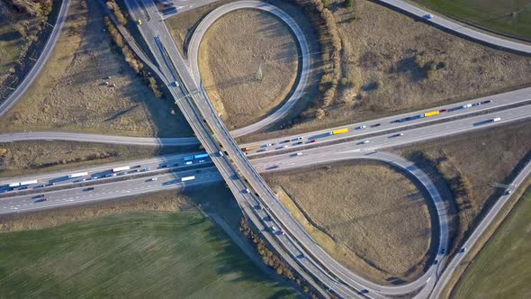 Aerial view of freeway intersection with moving traffic cars.