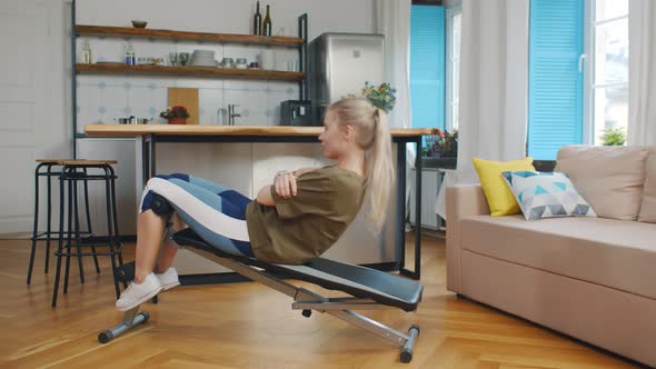 Side View of Young Woman Doing Work Out on Exercise Bench at Home