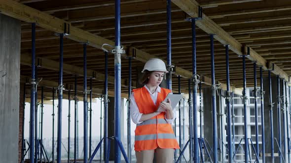 Engineer or Architect working at Construction Site. A woman with a tablet at a construction site