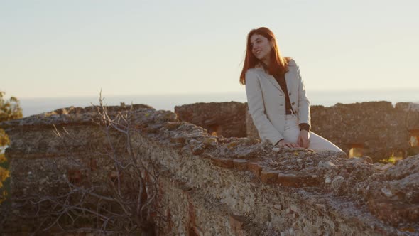 girl sitting on ancient castle walls