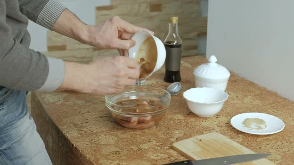 Unrecognizable Man Makes Sauce Marinade for Chicken and Dumps It on the Chicken in the Dish