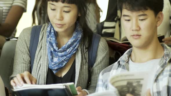 Group of college students sitting on steps and studying