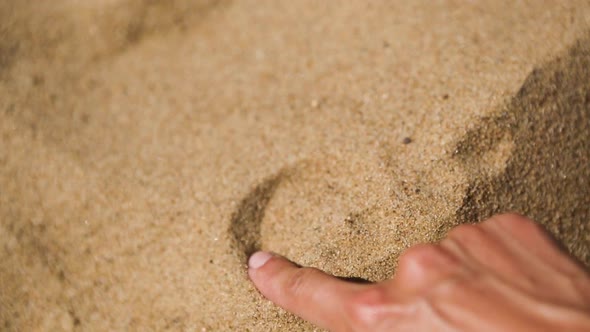 Drawing a heart on the sand with your finger is a sign of love for a beach holiday