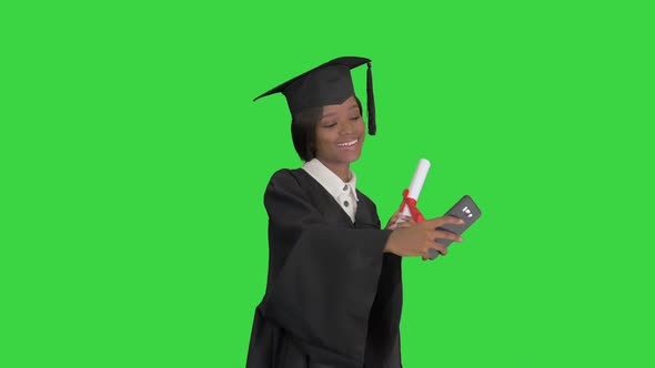 Happy African American Female Graduate Holding Diploma and Making Selfie on a Green Screen, Chroma