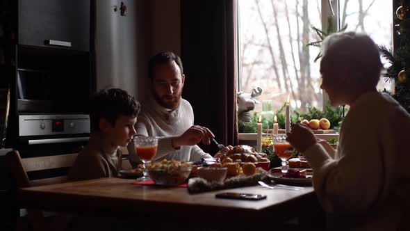 Happy Caucasian Family Mother Father and Lovely Little Son Enjoying at Festive Christmas Table