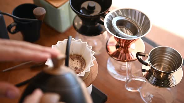 The barista is brewing coffee with traditional drip brewing equipment.