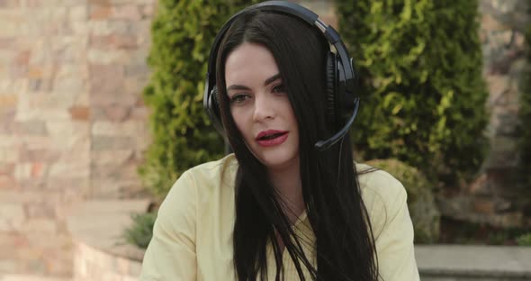 Portrait of Blogger Talking on the Radio Microphone to the Camera in Garden