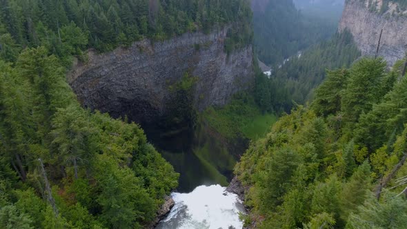 Beautiful water fall through forest cliff on a sunny day 4k