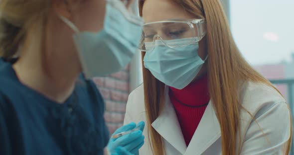 American Doctor Wearing Face Mask Injects a Covid19 Vaccine Into the Girl Shoulder at Home