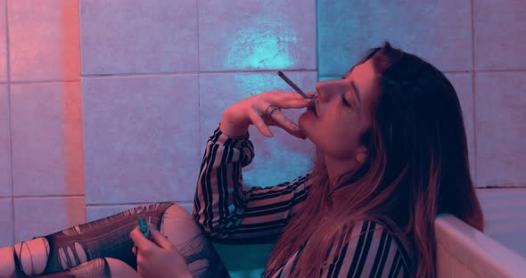 problems, depression - stoned girl in torn pantyhose smokes a joint of weed