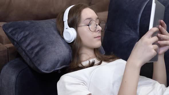 A Girl at Home with a Tablet on Her Headphones